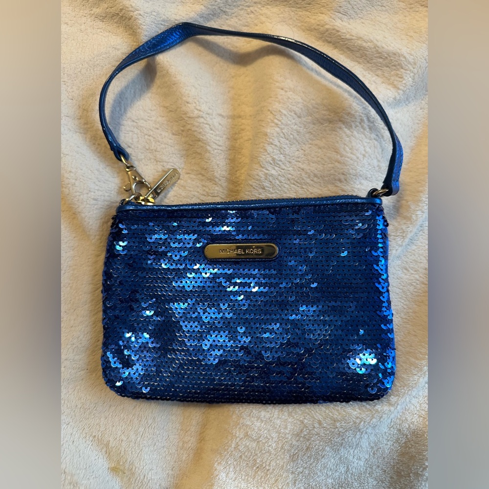 Michael Kors sapphire blue sequined wristlet with gold colored hardware.